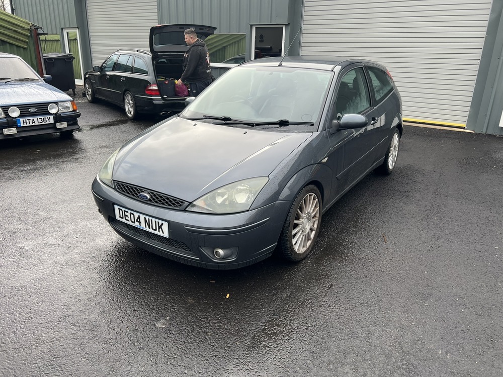 Ford Focus ST170 parked in front of workshop doors