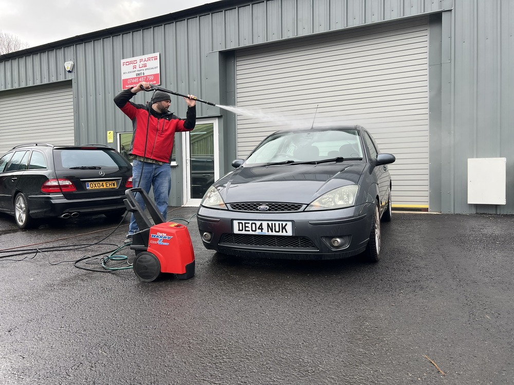 Man pressure-washing Ford Focus ST170
