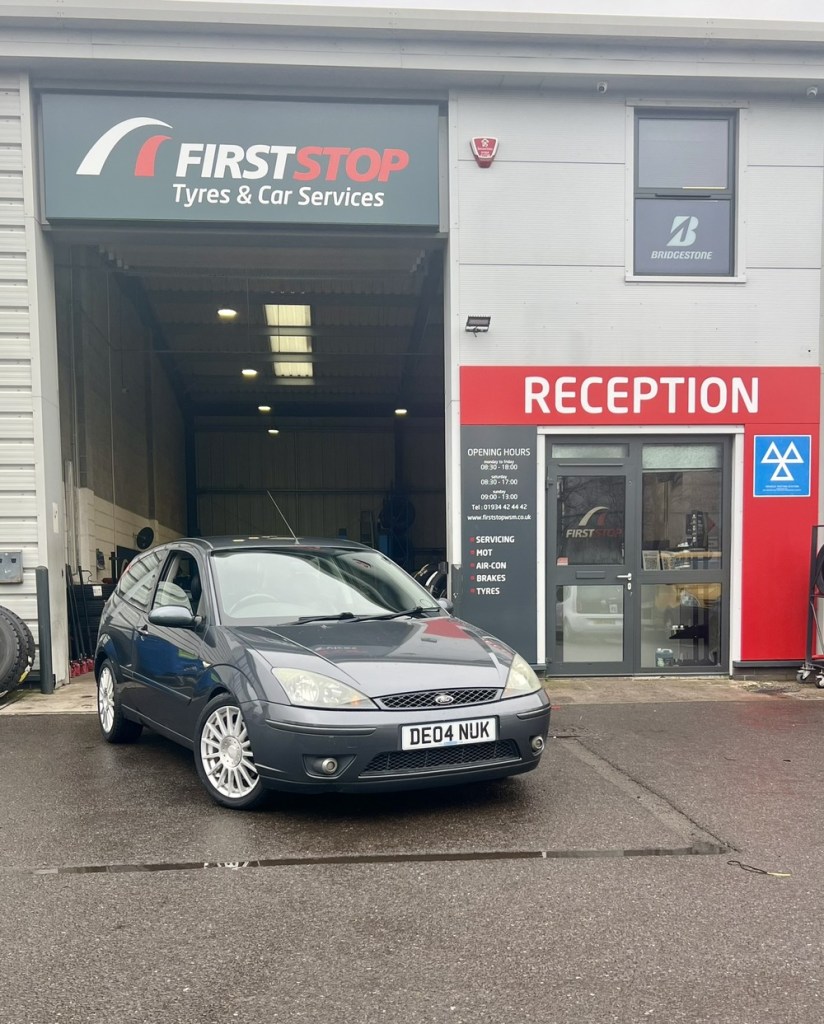 Ford Focus ST170 parked in front of tyre fitting workshop.