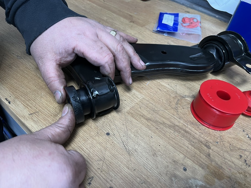 man fitting front wishbone bush