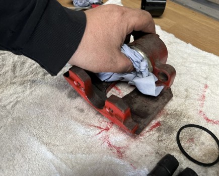 cleaning brake caliper with blue paper towel